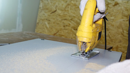 Working with an automatic electric saw works in a carpentry workshop.