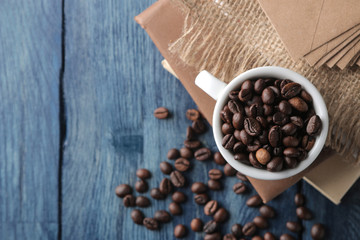 coffee cup for espresso and coffee beans on a blue wooden table with place for text. Top view