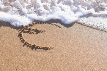 Euro sign written in the sea sand. Waves washed away the inscription.