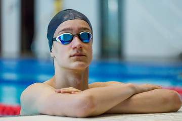 Portrait of athletic teenage boy at the sports pool.