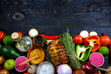 Delicious steakhouse porterhouse steak and colorful fresh roast vegetables on a black board, view...