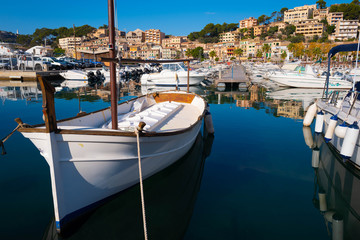 Small white boat anchored in the harbor surrounded by other boats.