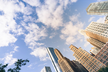 Vintage tone look up view of typical skyline office building in Chicago downtown against cloud blue sky