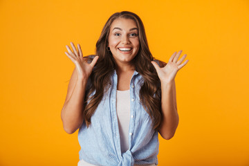 Excited young woman posing isolated over yellow wall background. - obrazy, fototapety, plakaty