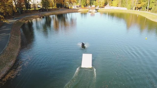 Flying over wakeboarding on river 4k aerial video.