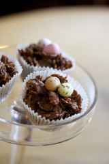 Three chocolate cornflake cake with mini eggs on a cake stand