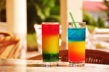 Two tropical multicolored cocktails.
