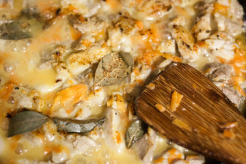 Stew chicken pieces in a pan with vegetables and spices. the sauce is boiling. selective focus.
