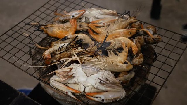 Grilled Shrimp, shellfish and crab on stove grille , cooking barbecue seafood.