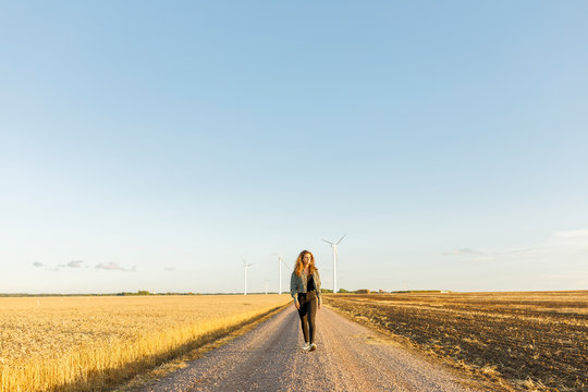 Teenage girl walking on rural road in Vaderstad, Sweden