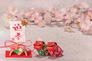 Japanese New Year's Cards with red handwriting ideograms Geishun which means Welcoming Spring with folklore lions Shishimai, rice paper and bamboo ornament on silver background with cherry blossoms. 