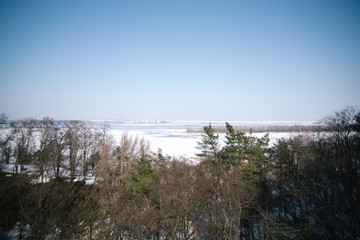 A spring sunny day in a snowy park