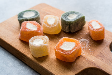 Fruity Turkish Delight Roll Shaped on Wooden Board.