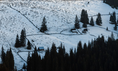 wooden house in a perfect snowy winter landscape. Snow covered rural and forest landscape.