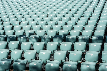 blue empty seats in a stadium on a sunny day