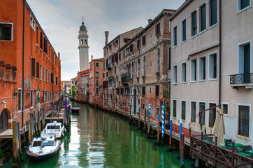 Fototapeta na wymiar View of Canal with boats and gondolas in Venice, Italy