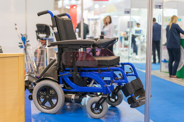 Wheelchair at a medical exhibition. Wheelchair with electric motor