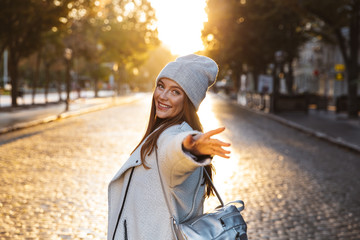 Cheerful young woman dressed in autumn coat