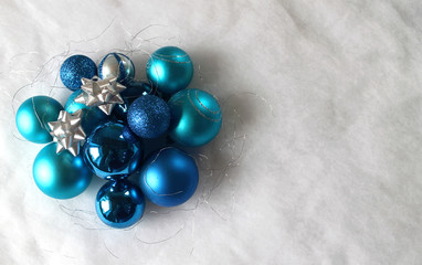 Silver and blue christmas balls on white snowy background