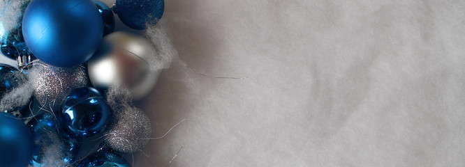 Silver and blue christmas balls on white snowy background