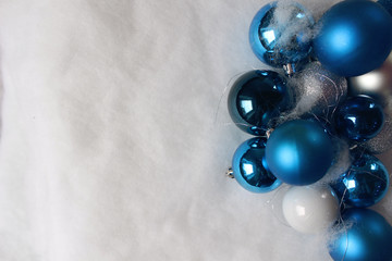 Silver and blue christmas balls on white snowy background