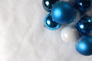 Silver and blue christmas balls on white snowy background