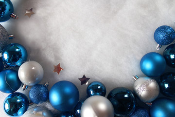 Silver and blue christmas balls on white snowy background