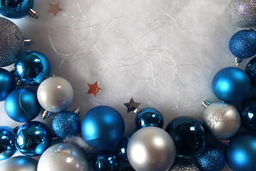 Silver and blue christmas balls on white snowy background