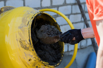 Builder Using Concrete Mixer On Building Site.