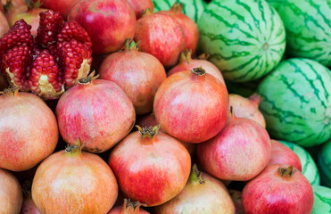 Fototapeta na wymiar Ripe pomegranates and watermelons. Bright fruit background (Selective focus)