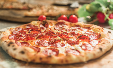 Hot pizza slice with melting cheese on a rustic wooden table.