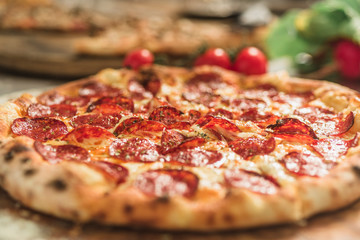 Hot pizza slice with melting cheese on a rustic wooden table.