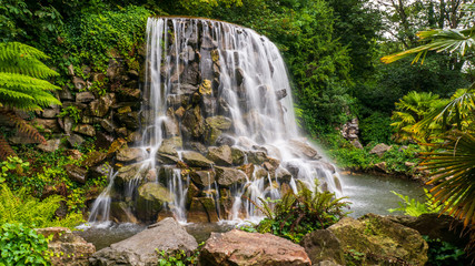 Long exposure of one of the Dublin's hidden gems, a lovely waterfall in Iveagh Gardens, in the city center, side view. Calm landscape in Ireland.