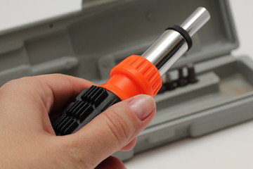 Master holds in his hands a screwdriver. Screwdriver set in box on white background.