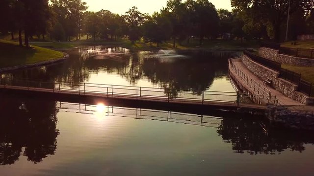The sun reflecting off the water by the bridge