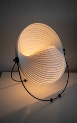 Lampe blanche modulable allumée éclipse mobilier vintage des années 70 sur un meuble buffet...