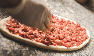 Hot pizza slice with melting cheese on a rustic wooden table.