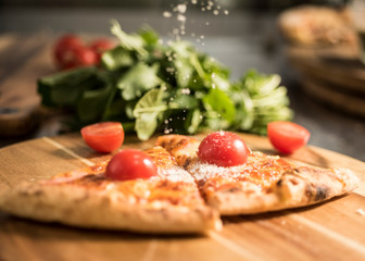 Hot pizza slice with melting cheese on a rustic wooden table.