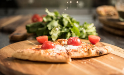 Hot pizza slice with melting cheese on a rustic wooden table.