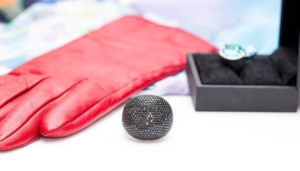 silver ring with lots of black zircons on the background of gloves and another ring
