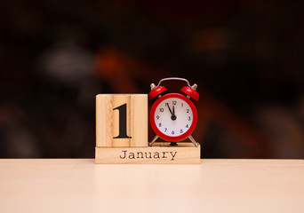 Naklejka premium January 1st. Day 1 of January set on wooden calendar with dark background. Winter time.
