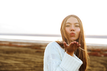 Beautiful young girl sending a kiss to camera