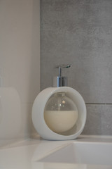 Distributeur de savon liquide fome bulle, blanc sur un rebord de lavabo design moderne et épuré