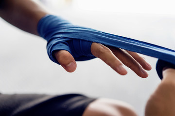 Close up male hand of boxer with blue boxing bandages. Fists fighter before the fight.sport