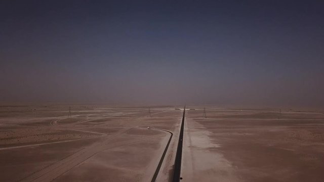 Aerial view of a long staright road going though the desert in Dubai