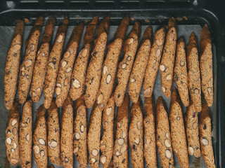 Italian Biscotti cookies dry on the baking sheet.  The cookies are lined in rows.