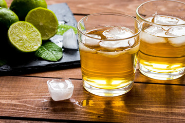 glass of whiskey on wooden background
