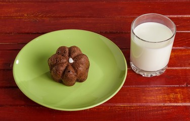 Cake on a plate and a glass of milk on the table.