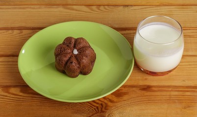 Cake on a plate and a glass of milk on the table.