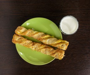 Puff pastry on a plate and a glass of milk on the table.